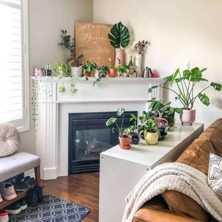 a corner fireplace with plants and flowers