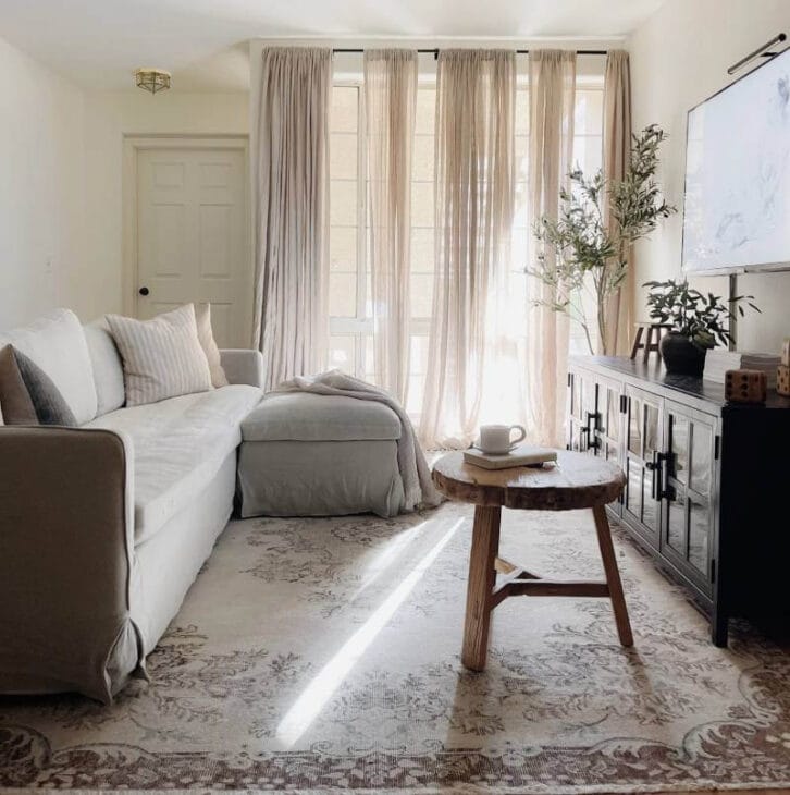 a long narrow living room with airy curtains