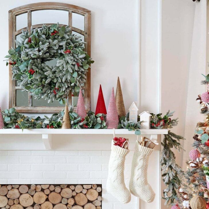 a winter fireplace mantel with a wreath hanged above it