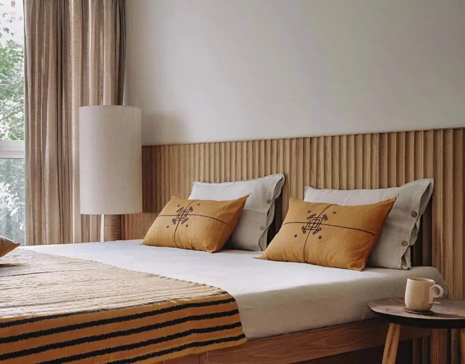 a japandi bedroom with a minimalist wood headboard
